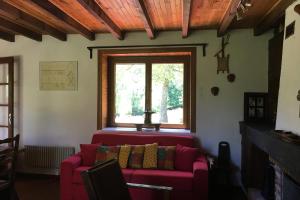 a living room with a red couch and a window at Maison bucolique en Chartreuse in Chenevey