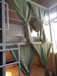 a bunk bed with green curtains in a room at Y.U.A.N in Kluang