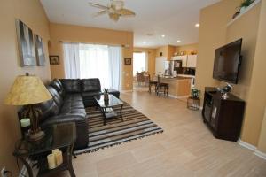 a living room with a black leather couch and a table at Luxury Villa Private Pool And Great Game Room in Kissimmee