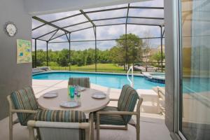 a dining area with a table and chairs next to a pool at Luxury Villa Private Pool And Great Game Room in Kissimmee