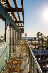 una fila di sedie seduta su un balcone con vista sulla spiaggia di Hotel Erwin Venice Beach a Los Angeles