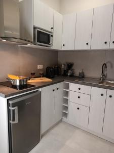 a kitchen with white cabinets and a microwave at Ilios studios in Vasiliki +24 photos
