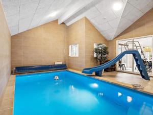 a indoor swimming pool with a slide in a room at Holiday home Henne VI in Henne Strand