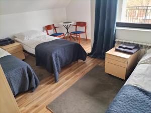 a bedroom with two beds and a table and chairs at Pensjonat u Joli in Sandomierz
