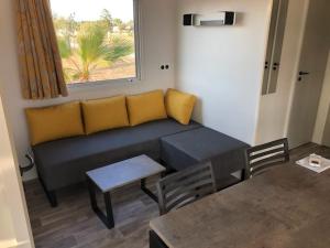 a living room with a couch and a table at Camping Les Pins maritimes in Hyères
