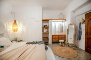 a bedroom with a bed and a dressing room at Ninémia Sea living in Archangelos +26 photos