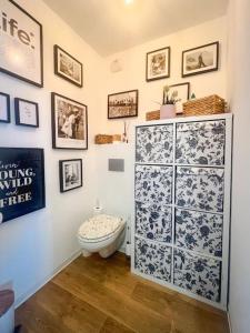 a bathroom with a toilet and a wall with pictures at Tram C La belle Rose Logement proche Gare Bordeaux in Bègles