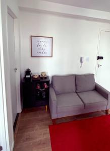 uma sala de estar com um sofá e um tapete vermelho em Apartamento no Butantã em São Paulo