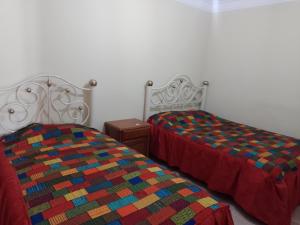 two beds sitting next to each other in a bedroom at HoSTAL SANTA BARBARA in Torotoro