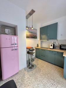 Il comprend une cuisine équipée d'un réfrigérateur rose et d'un tabouret. dans l'établissement Alicante Beach Home, à Alicante