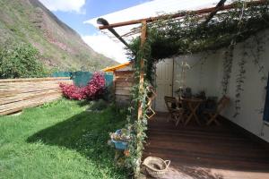 a house with a wooden deck with a table at House for 3 people in Urubamba in Urubamba