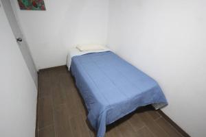 a small bed with a blue blanket in a room at House for 3 people in Urubamba in Urubamba