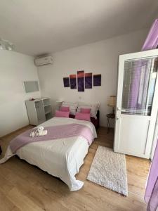 ein Schlafzimmer mit einem großen Bett mit rosa Kissen in der Unterkunft Apartments Ivana Bibinje in Bibinje