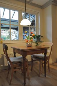 uma mesa de jantar com um vaso de flores em B&B Slotstraat em Dreischor