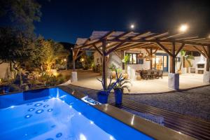 a hot tub in front of a house at night at Ninémia Sea living in Archangelos