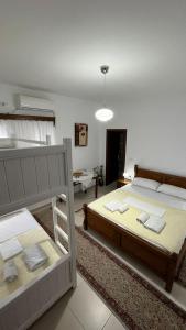 a bedroom with two beds and a bunk bed at Cico Hostel &private room in Gjirokastër