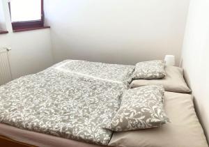 a bed in a room with two pillows on it at Apartmán na Valašsku in Horní Bečva