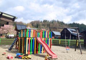 a colorful playground with a slide and a play set at Apartmán na Valašsku in Horní Bečva