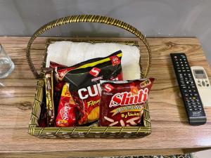 a basket of snacks and a remote control on a table at Serene Private Room in Karachi