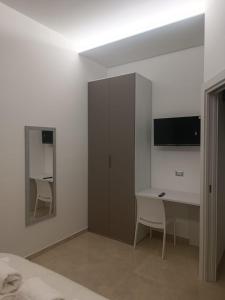 1 dormitorio con escritorio, 1 cama y espejo en Villa Matilde Monteroni, en Monteroni di Lecce