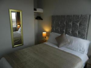 a bedroom with a large bed and a mirror at Ocean Bay in Blackpool