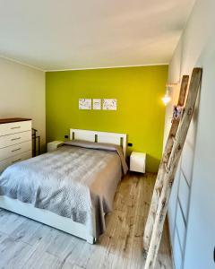 a bedroom with a bed and a yellow wall at 2 Cuori al Lago - Appartamento in villetta singola in Mandello del Lario