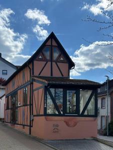 um edifício com um telhado de gambrel numa rua em Gemütliches Scheunenfachwerkhaus em Bad Soden am Taunus