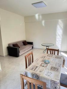 a living room with a table and chairs and a couch at Adoniss Apartmentss in Paralia Dionysiou