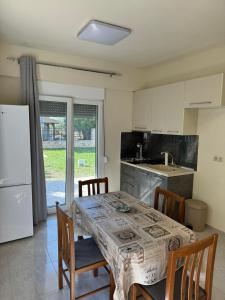 a kitchen with a table with chairs and a refrigerator at Adoniss Apartmentss in Paralia Dionysiou