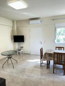 a living room with a table and a tv at Adoniss Apartmentss in Paralia Dionysiou