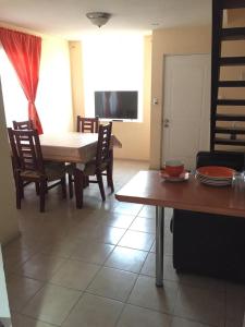 a living room with a table and chairs and a television at Casas Amobladas y Equipadas Calama in Calama