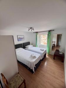um quarto com 2 camas e uma janela em Apartments Tudor Nikola em Hvar