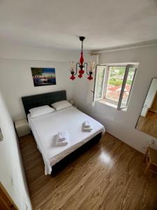 - une chambre avec un lit blanc et une fenêtre dans l'établissement Apartments Tudor Nikola, à Hvar