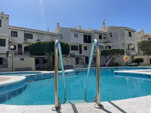 a swimming pool in front of a large building at Hidden Gem Playa Flamenca Apartment with Pool View - Oleza Garden in Playa Flamenca