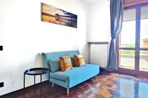 un soggiorno con divano blu e tavolo di Attico con Parcheggio Privato a Crema