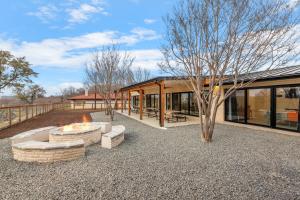 a house with a fire pit and a tree at Guadalupe Bluff Modern House in Kerrville