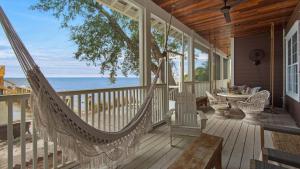 Un porche con hamaca y vista al mar. en Dock of the Bay, en Santa Rosa Beach