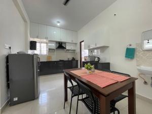 a kitchen with a table with chairs and a refrigerator at SSN Home Stays in Bangalore near PLAY Arena in Bangalore