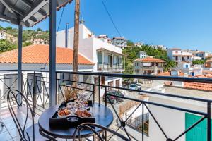 a table on a balcony with a view of a city at House Victoria in Skopelos Town