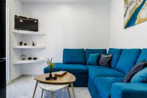 a blue couch in a living room with a table at Victoria House in Skopelos Town