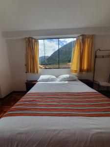 a bedroom with a large bed with a large window at shanti pisac in Pisac