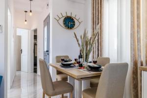 a dining room table with chairs and a clock on the wall at Victoria House in Skopelos Town