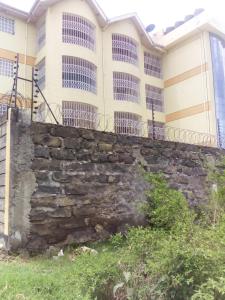 a stone retaining wall in front of a building at Top tier A 01 in Nakuru
