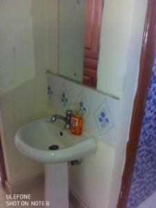 a bathroom with a white sink and a mirror at Top tier A 01 in Nakuru