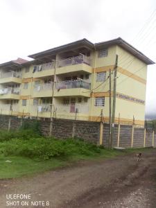 an apartment building on the side of a dirt road at Top tier A 01 in Nakuru
