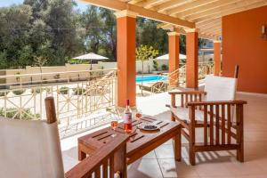 a patio with a table and chairs and a pool at Villa Loukiana in Kavos