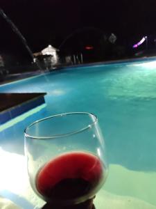 una copa de vino tinto junto a la piscina en Tierra Linda Campestre en Guamal