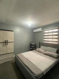 Un dormitorio con una cama grande y una ventana. en 2 Bedroom House in Camella Carcar Cebu, en Guinauayan
