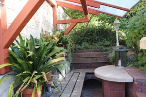 patio z ławką, stołem i roślinami w obiekcie Kleine Wohngelegenheit w mieście Chemnitz
