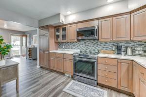 a large kitchen with wooden cabinets and appliances at Newly Remodeled Home in Storm Lake with Private Yard in Storm Lake